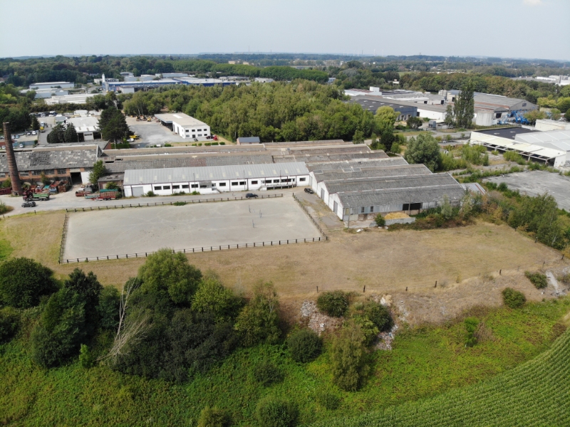 
8.500 m² magazijn op 30.000 m² grond met kantoren van +/- 650 m² omgevormd tot appartement te koop te Manage in een industriële zone